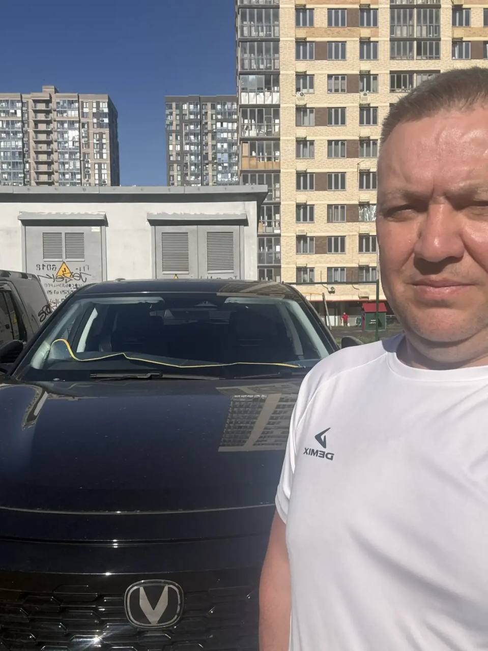 Покупатель рядом с полученным автомобилем Changan
